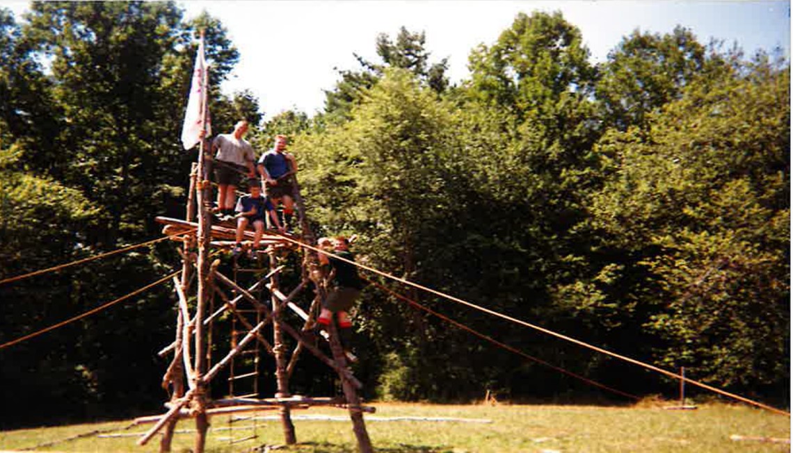 Mike climbing a wooden tower during an outdoor expedition